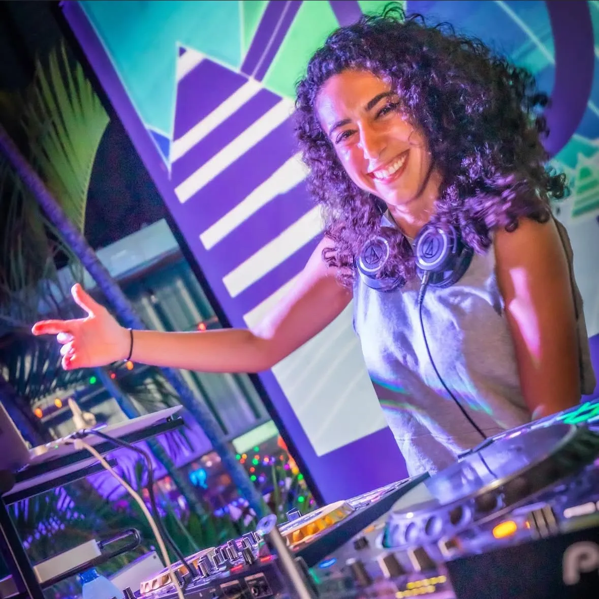 Merav in the booth under purple light