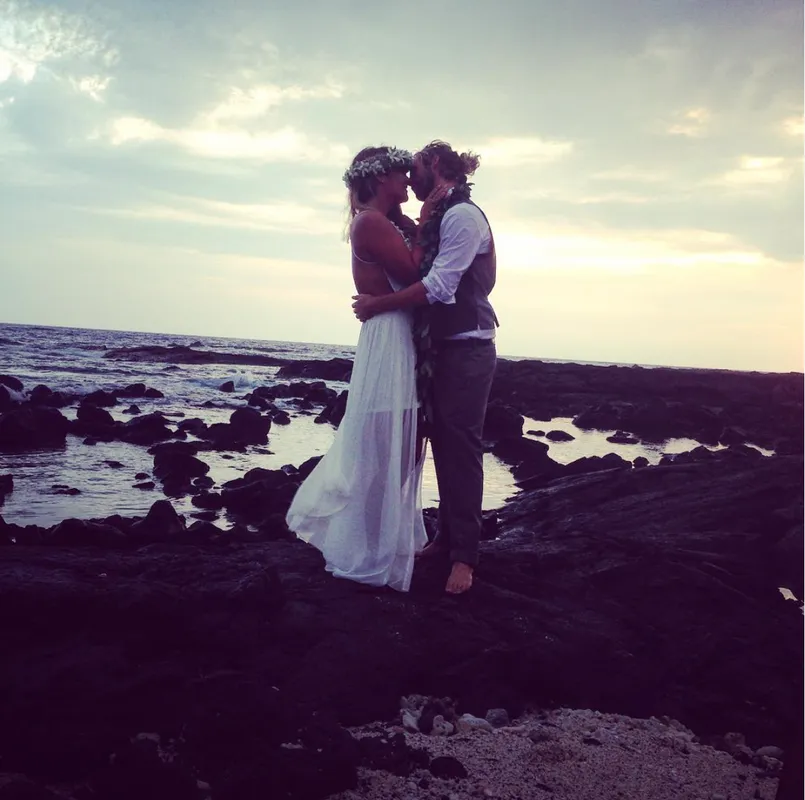 Newlyweds on the rocks at sunset